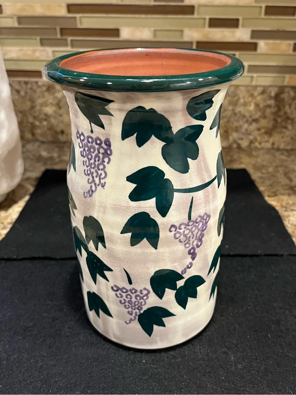 Handmade pottery vase cream-colored with a green and purple grape vine motif
